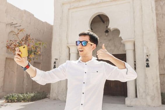 पुराने बुर दुबई खाड़ी जिले में वीडियो ब्लॉग रिकॉर्ड करता व्यक्ति।