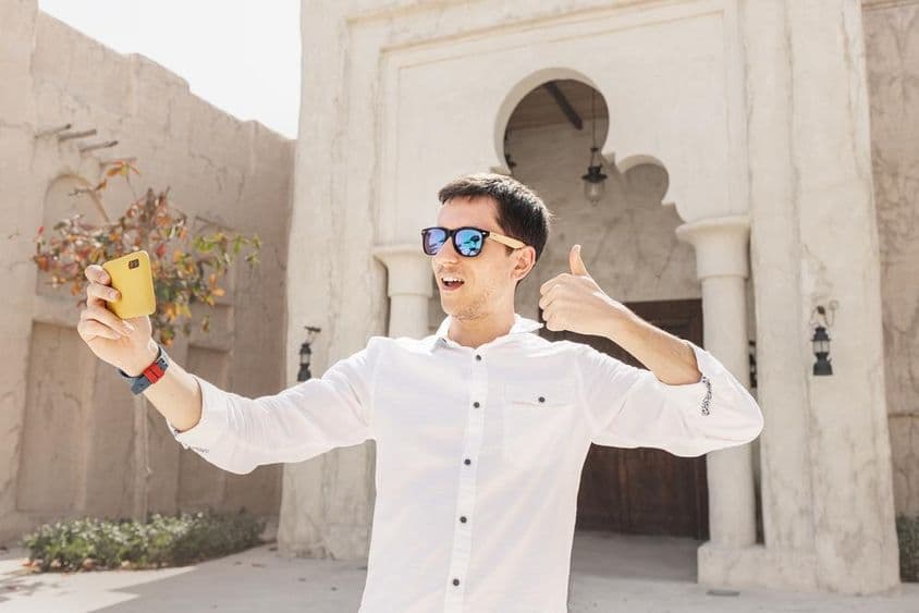 पुराने बुर दुबई खाड़ी जिले में वीडियो ब्लॉग रिकॉर्ड करता व्यक्ति।