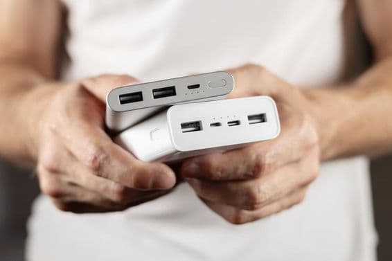 हाथ में पकड़ी दो बाहरी बैटरियां।