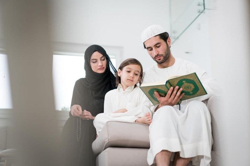 एक युवा अभिभावक और एक छोटा लड़का एक किताब पढ़ रहे हैं।