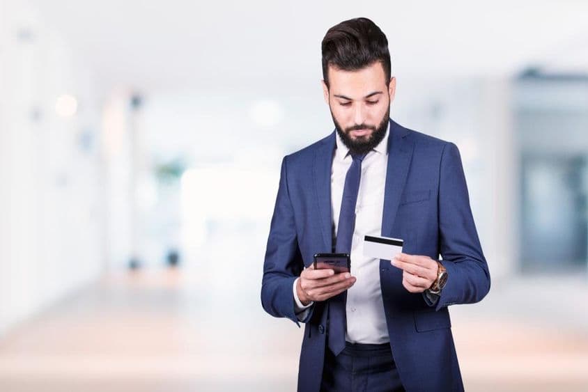 अरब व्यवसायी स्मार्टफोन और क्रेडिट कार्ड के साथ।