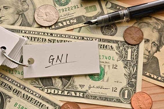 टेबल पर डॉलर के बिलों के ऊपर लिखा जीएनआई वित्तीय शब्द।