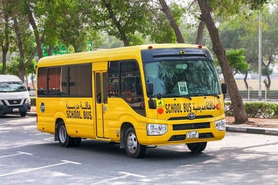 दुबई शहर की सड़क पर टोयोटा कोस्टर स्कूल बस।