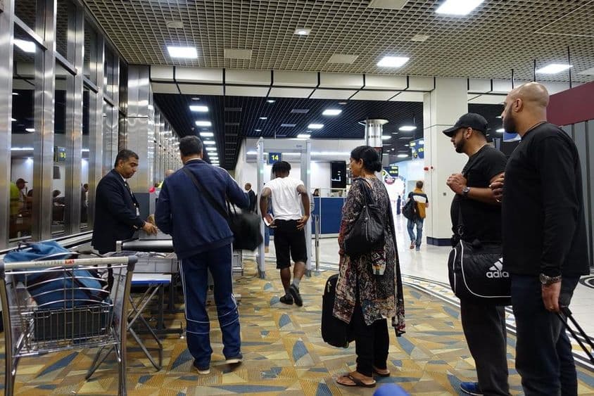 हवाई यात्रियों को दुबई अंतरराष्ट्रीय हवाई अड्डे पर सुरक्षा जांच के दौरान गुजरते हुए।