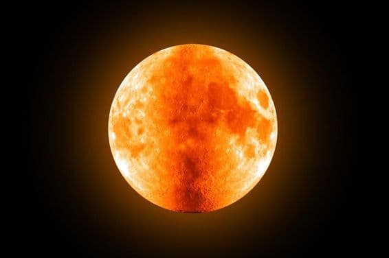 आकाश में लाल पूर्ण चंद्रमा।