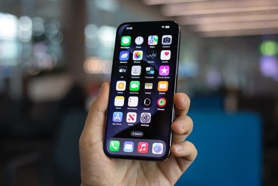 आदमी iPhone 15 प्रो मैक्स पकड़े हुए।