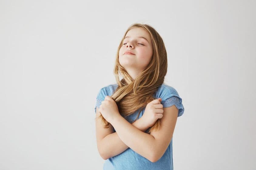 सुंदर सुनहरे बालों वाली लड़की ताजा हवा की गहरी सांस ले रही है।