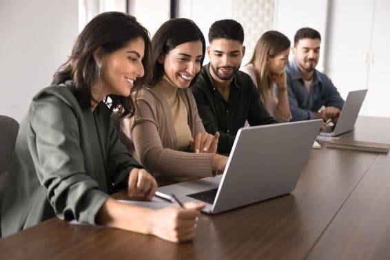 एक शैक्षणिक केंद्र में लैपटॉप पर अध्ययन कर रहे बहुराष्ट्रीय युवा वयस्क छात्र।