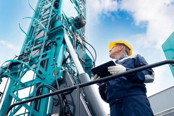 ड्रिलिंग प्लेटफार्म को नियंत्रित करने के लिए डिजिटल टैबलेट का उपयोग करता एक उद्योग ऑपरेटर।