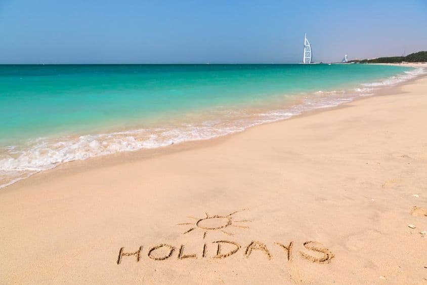 फ़िरोज़े पानी के साथ समुद्र तट पर अवकाश चिह्न।