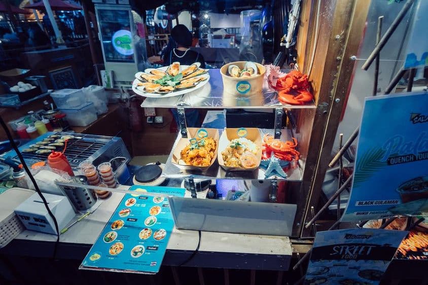 ग्लोबल विलेज, दुबई में स्ट्रीट फूड्स के साथ फ्लोटिंग रेस्त्रां पर पारंपरिक थाई व्यंजन।