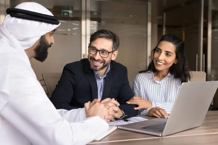 एक खुशहाल लैटिन जोड़ा एक अरब रियल एस्टेट एजेंट के साथ बैठक कर रहा है।