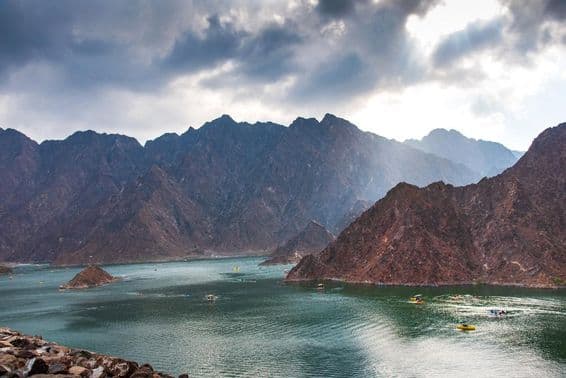 दुबई, यूएई में सूर्यास्त के समय हट्टा डैम झील का दृश्य।