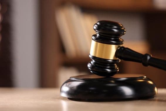 लकड़ी की डेस्क पर न्यायाधीश का हथौड़ा।