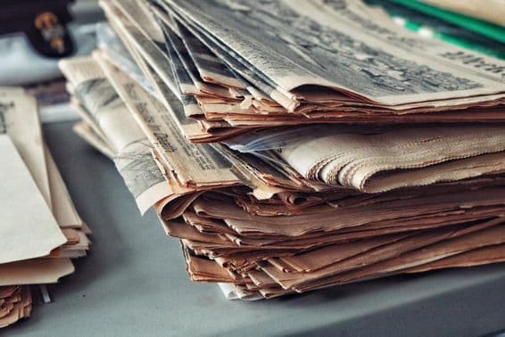 जाले लगे पुराने अखबारों का ढेर।