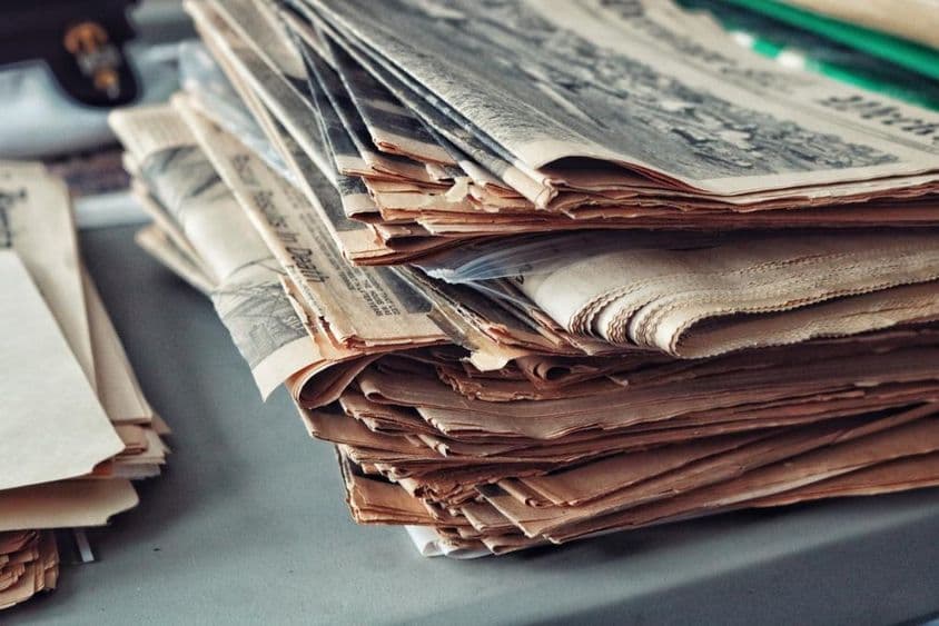 जाले लगे पुराने अखबारों का ढेर।