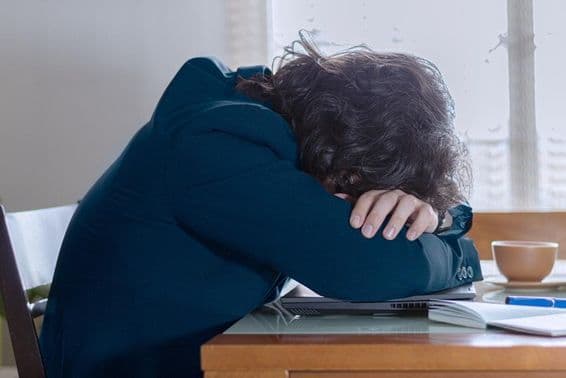 सोमवार को अपने काम पर लैपटॉप पर आराम करते हुए एक व्यक्ति।