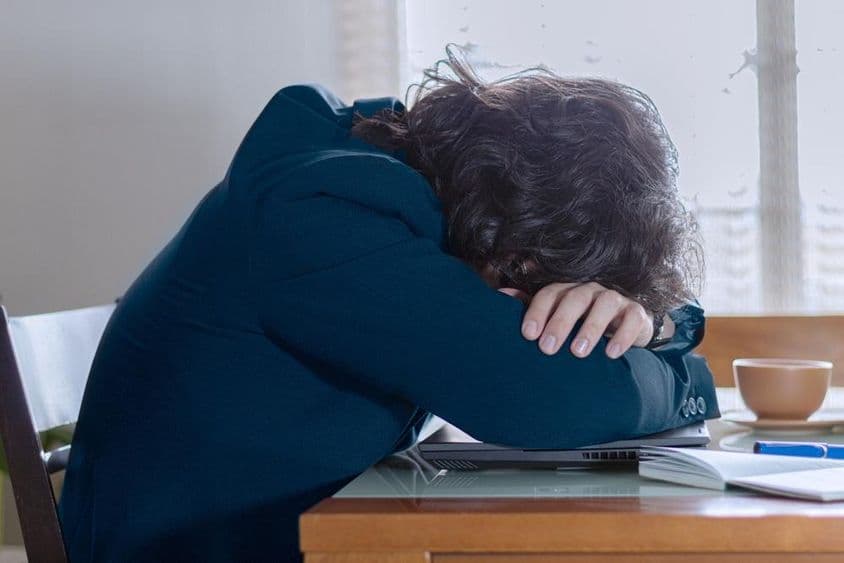 सोमवार को अपने काम पर लैपटॉप पर आराम करते हुए एक व्यक्ति।