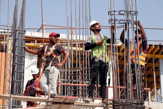 दुबई में निर्माण में काम करते पुरुष।