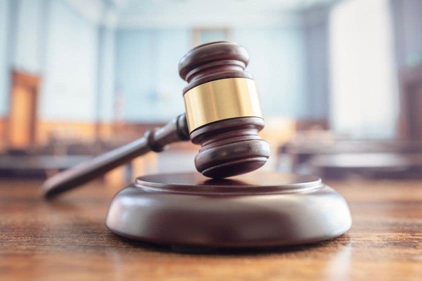 न्यायाधीश का हथौड़ा बेंच पर।