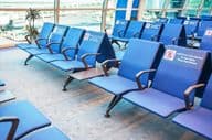 एयरपोर्ट प्रतीक्षालय में सीटों की पंक्तियाँ।