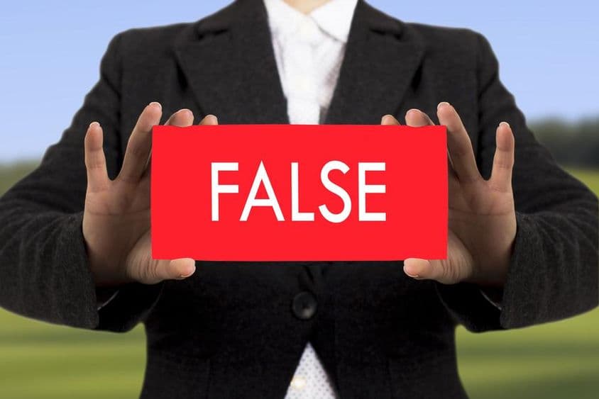 काले जैकेट में व्यवसायी महिला नकली लेख के साथ कार्ड पकड़े हुए।
