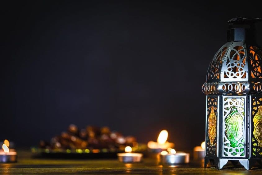 सूरज ढलती आकाश के नीचे एक रमजान की मोमबत्ती।