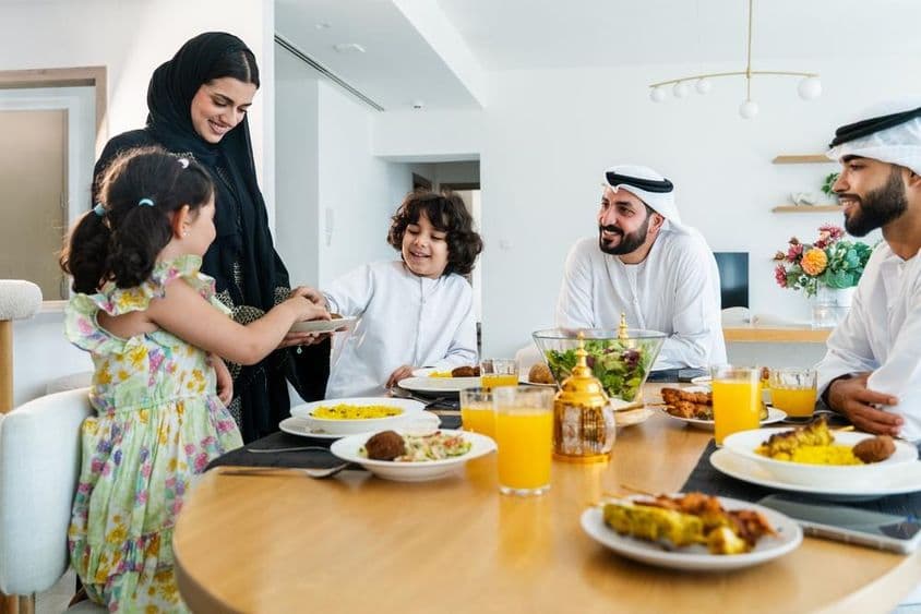रमज़ान के दौरान रात के खाने के बाद घर में एक साथ खुश अरब परिवार।