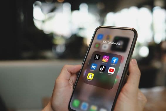 सोशल मीडिया ऐप आइकनों के साथ iPhone १५ प्रो स्क्रीन।
