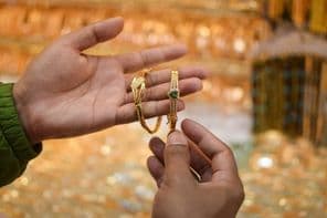 एक आभूषण की दुकान में लक्जरी सोने का कंगन आजमाती हुई एक हाथ।